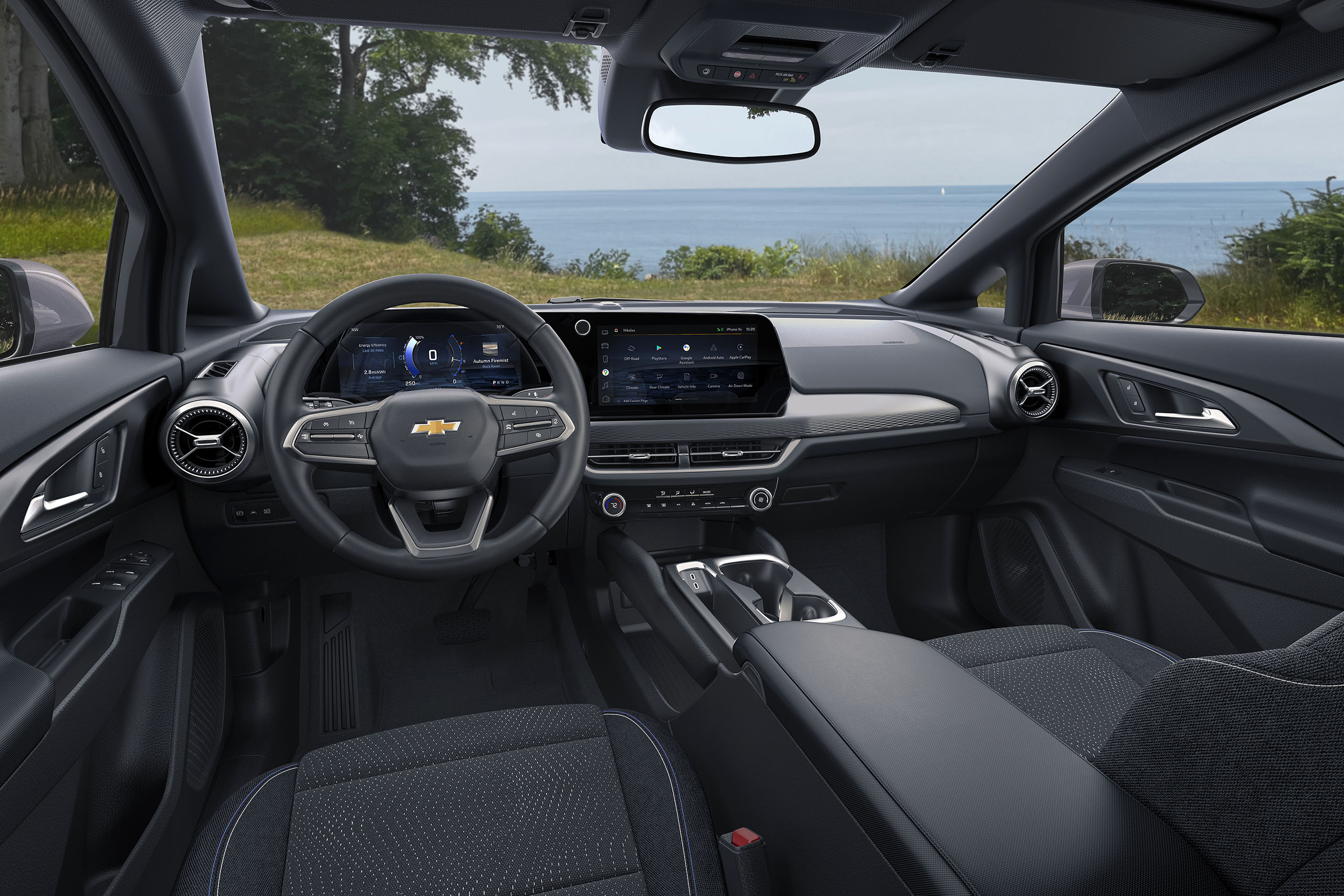 Vue large de la cabine avant en 2024 Chevrolet Equinox EV 1LT avec noir avec accents bleus intérieur. Modèle de préproduction montré. Le modèle de production réel peut varier. Visitez Chevy.com/equinoxev pour la disponibilité.